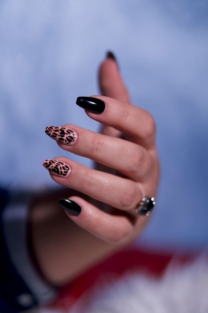 Mastering the First Impression: Your intriguing post title goes here Elegant hand with leopard print and black manicure on fingernails, showcasing nail art creativity.