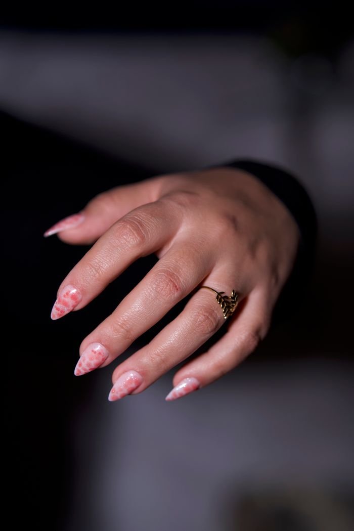 Crafting Captivating Headlines: Your awesome post title goes here Close-up shot showcasing intricate pink nail art and gold ring on a woman's hand.